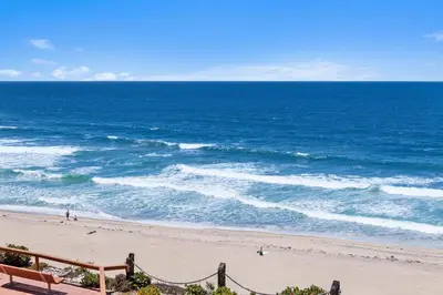 a view of the ocean from a beach with a bench at Once Upon A Tide - SBTC312 in Solana Beach