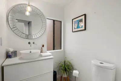 a white bathroom with a sink and a mirror at Hacienda Palms - SUR168 in Solana Beach