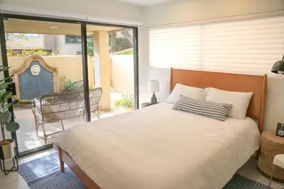 a bedroom with a large bed and a balcony at Hacienda Palms - SUR168 in Solana Beach