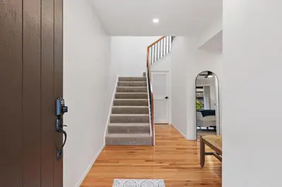 a staircase in a house with white walls and wooden floors at Mermaid's Lookout in San Diego