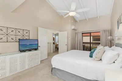 a white bedroom with a large bed and a flat screen tv at Seaside Splash - SBTC169 in Solana Beach