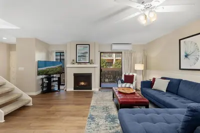 a living room with a blue couch and a fireplace at Seaside Splash - SBTC169 in Solana Beach