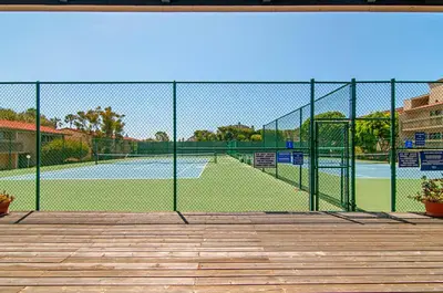 a tennis court seen through a chain link fence at Seaside Splash - SBTC169 in Solana Beach