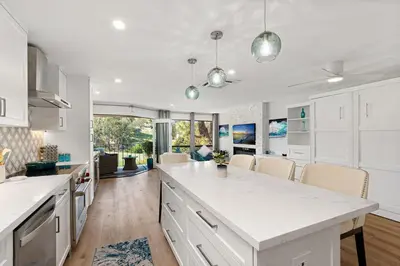 a kitchen with white cabinets and a large kitchen island at Fairway Haven - CB2507 in Carlsbad