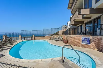 a swimming pool with chairs and a building at Sea Den - DMST45 in Solana Beach