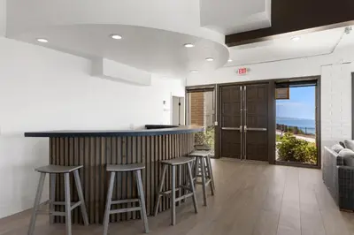 a kitchen with a bar and stools in a room at Whale Watch - DMST12 in Solana Beach