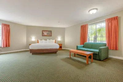 a hotel room with a bed and a chair at Hotel Avenida, San Clemente Beach in San Clemente
