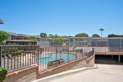 a swimming pool with a fence around it at Beachy Keen & Cleen - DMBC148S in Solana Beach