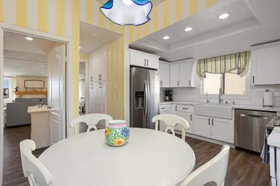 a kitchen with a white table and white cabinets at Dolphin View - SUR43 in Solana Beach