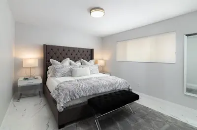 a white bedroom with a large bed and a window at Balboa Peninsula Beach House Fireplace Bikes in Newport Beach
