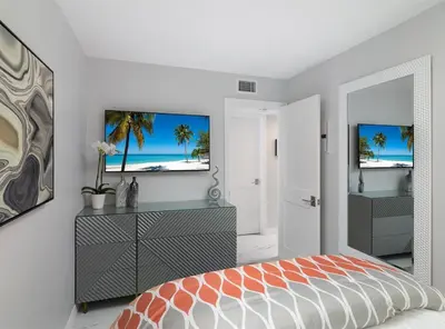 a bedroom with a bed and a tv on a wall at Balboa Peninsula Beach House Fireplace Bikes in Newport Beach