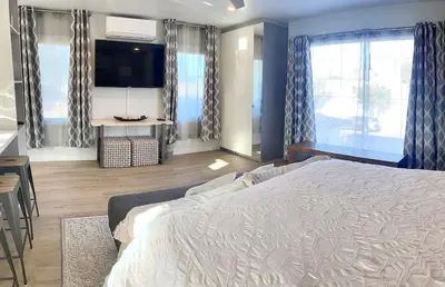 a bedroom with a large bed and a tv at Stunning Ocean Beach Gem - has everything! in San Diego