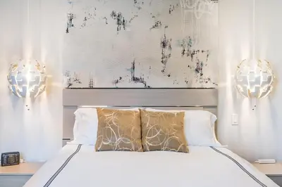 a bedroom with a white bed with two lights at Hotel-Style Independent Suite in Ocean Beach in San Diego
