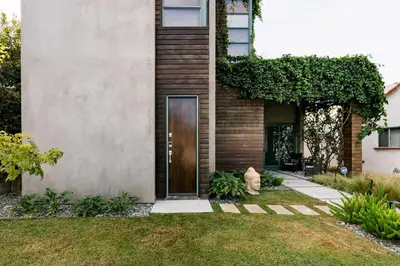 a house with a wooden door in a yard at Hotel-Style Independent Suite in Ocean Beach in San Diego