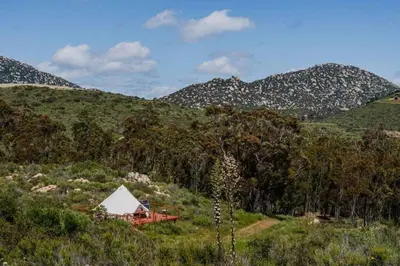 a tent on a hill with mountains in the background at Natures Nest in Poway