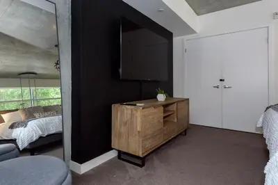 a bedroom with a bed and a dresser with a mirror at King Size Luxury Loft Petco-Park-Downtown SD in San Diego