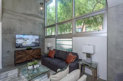 a living room with a couch and some windows at King Size Luxury Loft Petco-Park-Downtown SD in San Diego