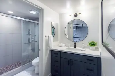 a bathroom with a sink and a shower with a mirror at King Size Luxury Loft Petco-Park-Downtown SD in San Diego