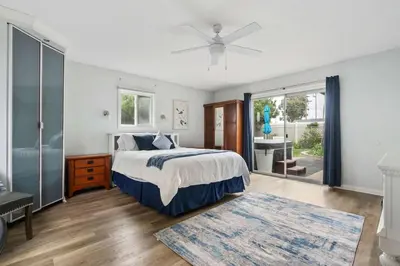 a bedroom with a bed and a large window at O-Side Beach Bungalow with Jaccuzi Blocks to beach in Oceanside