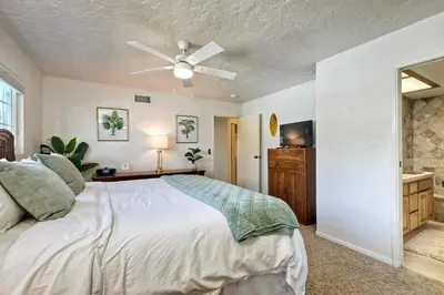 a bedroom with a bed and a ceiling fan at Hot Tub, Fire Pit, BBQ, Shuffleboard, Walk To Beach in Carlsbad