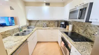 a kitchen with white cabinets and a sink at Luxurious and Spacious 2-Bedroom Condo Unit Downtown San Diego in the Heart of the Gaslamp Quarter - 14-Day Min in San Diego