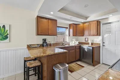 a kitchen with wooden cabinets and a counter top at Ocean Song in San Diego