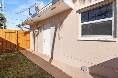 a house with a white door and a fence at Ocean Song in San Diego