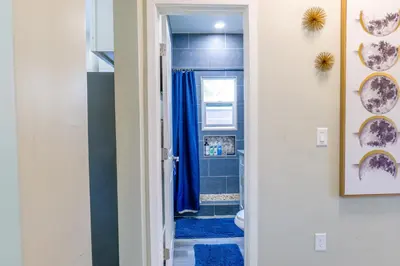a bathroom with a toilet and a blue shower curtain at 2BR Retreat Near Balboa Park in San Diego