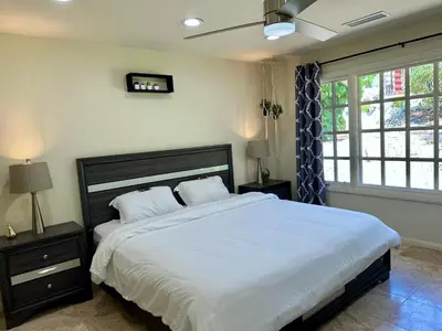 a bedroom with a large bed with white sheets at Hilltop Villa & Guesthouse, Pool Oasis, Pickleball Court in Fallbrook