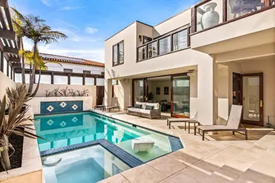 a home with a swimming pool and a house at Brand New Listing Elegant 7BR Masterpiece Walk to Beach Shops & Dining in San Diego