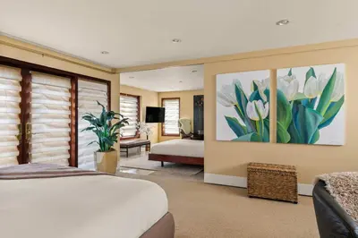 a bedroom with a bed and a painting on the wall at Brand New Listing Elegant 7BR Masterpiece Walk to Beach Shops & Dining in San Diego