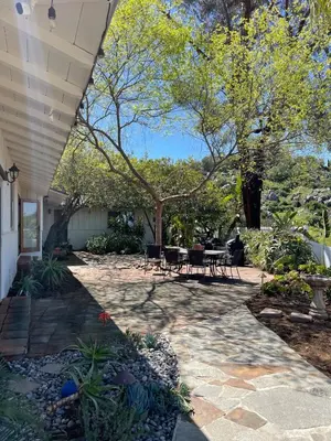 a patio with a table and chairs and trees at Avocado House in El Cajon