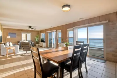 a dining room and living room with a table and chairs at Oceanfront Getaway - Ocean Views - Fire Pit - BBQ - Beach Access in Carlsbad