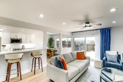 a living room with a couch and a kitchen at Balconies and Views Modern Abode in Poway! in Poway