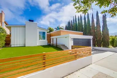 a house with a wooden fence and a green lawn at Sunset Path La Jolla Shores in San Diego
