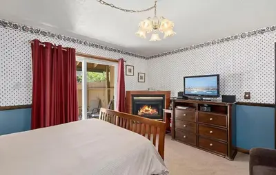 a bedroom with a bed and a tv and a fireplace at Autumn Room at Eaglenest Inn with Pool and SPA in Julian