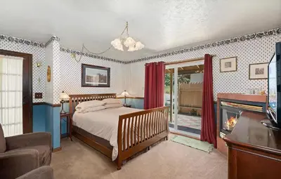 a bedroom with a bed and a fireplace at Autumn Room at Eaglenest Inn with Pool and SPA in Julian