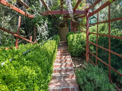 a brick walkway in a garden with a pergola at Autumn Room at Eaglenest Inn with Pool and SPA in Julian