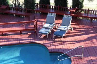 a group of chairs sitting next to a swimming pool at Autumn Room at Eaglenest Inn with Pool and SPA in Julian