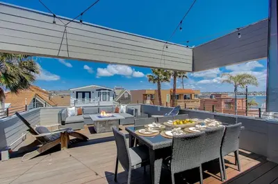 a patio with a table and chairs on a deck at Ocean View Luxury Beach Homes With AC and Parking in San Diego