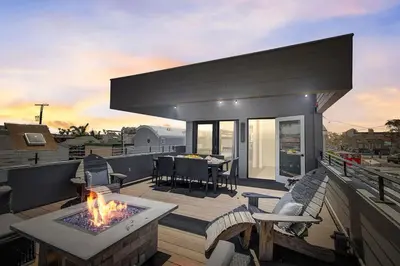 a patio with a fire pit and a table on a deck at Ocean View Luxury Beach Homes With AC and Parking in San Diego