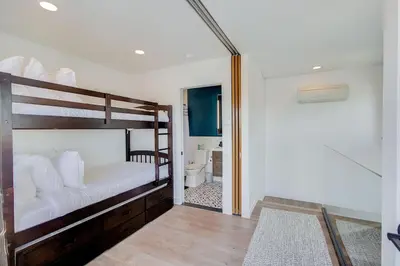a bedroom with two bunk beds and a bathroom at Ocean View Luxury Beach Homes With AC and Parking in San Diego