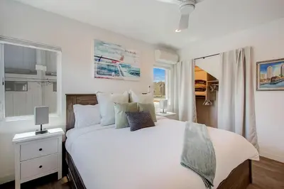 a bedroom with a large white bed and a window at Ocean View Luxury Beach Homes With AC and Parking in San Diego