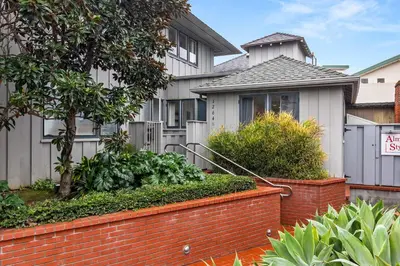 a house with a brick fence in front of it at Chic La Jolla Studio Steps to Ocean & Dining in San Diego