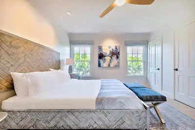 a bedroom with a large white bed and windows at La Jolla Shores Perfection with Hot Tub, Fence Yard, AC & Grill in San Diego
