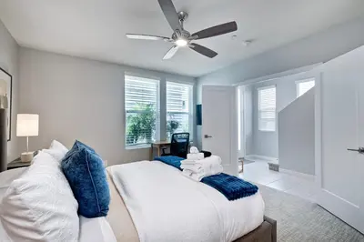 a bedroom with a bed with blue pillows and a ceiling fan at 301 Cassidy Street Unit 10 in Oceanside