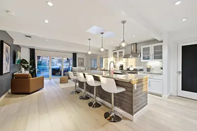 a kitchen and living room with a bar with stools at Ocean Views w Stunning Sunsets by the Firepit in San Diego