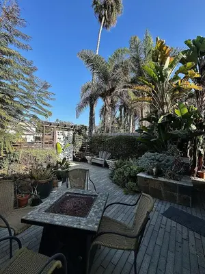 a patio with a table and chairs and palm trees at Close to Ocean and Beach in San Diego