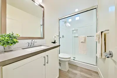 a white bathroom with a toilet and a glass shower at 343 Oak Avenue in Carlsbad