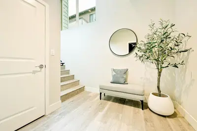 a hallway with a mirror and a tree in a vase at 343 Oak Avenue in Carlsbad